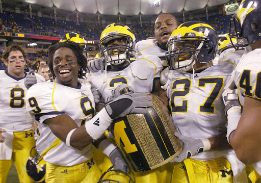 LEISA THOMPSON, The Ann Arbor News
U-M's Martavious Odoms, Stevie Brown, center, Carson Butler and Brandon Harrison and their teammates celebrate with the Little Brown Jug after their victory over Minnesota, 29-6,  Saturday at the Herbert H. Humphrey Metrodome.